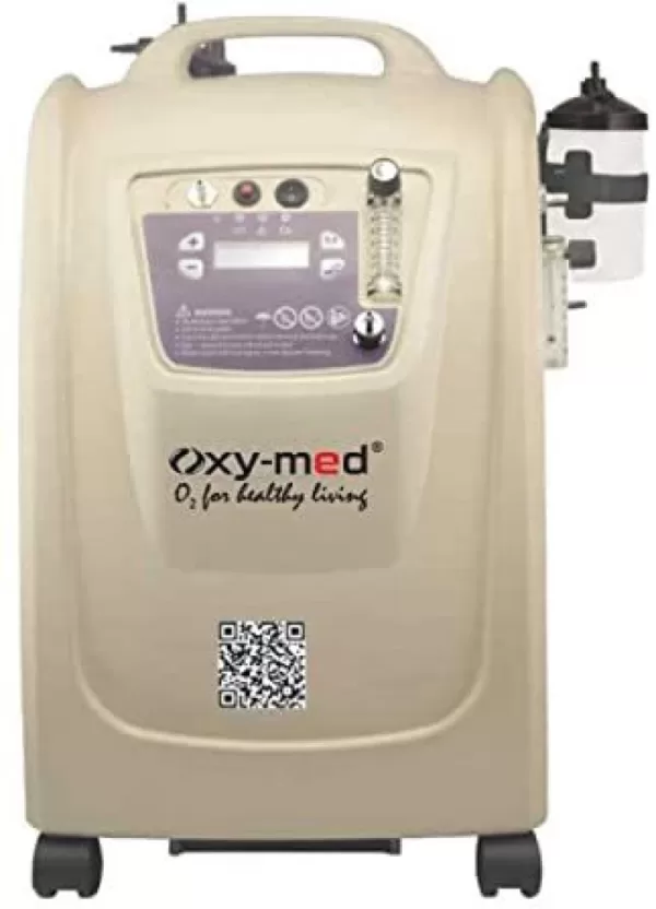 Oxy-med oxygen concentrator in beige color with digital display, flow meter, and humidifier bottle. The device has wheels for portability and features a handle on top. The brand name "oxy-med" and slogan "oxygen concentrator for rent"